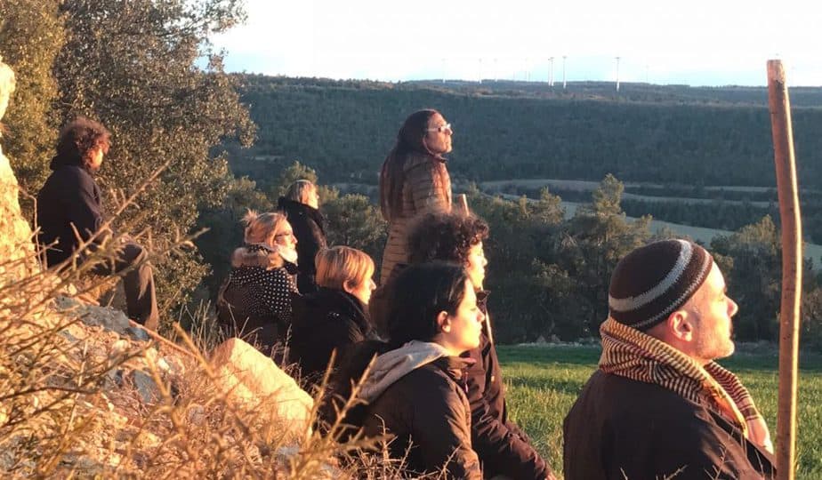 Participantes sentados frente a una puesta de sol en nuestro retiro de meditación y creatividad, en el Ashram de la Creativitat, Segura, Tarragona